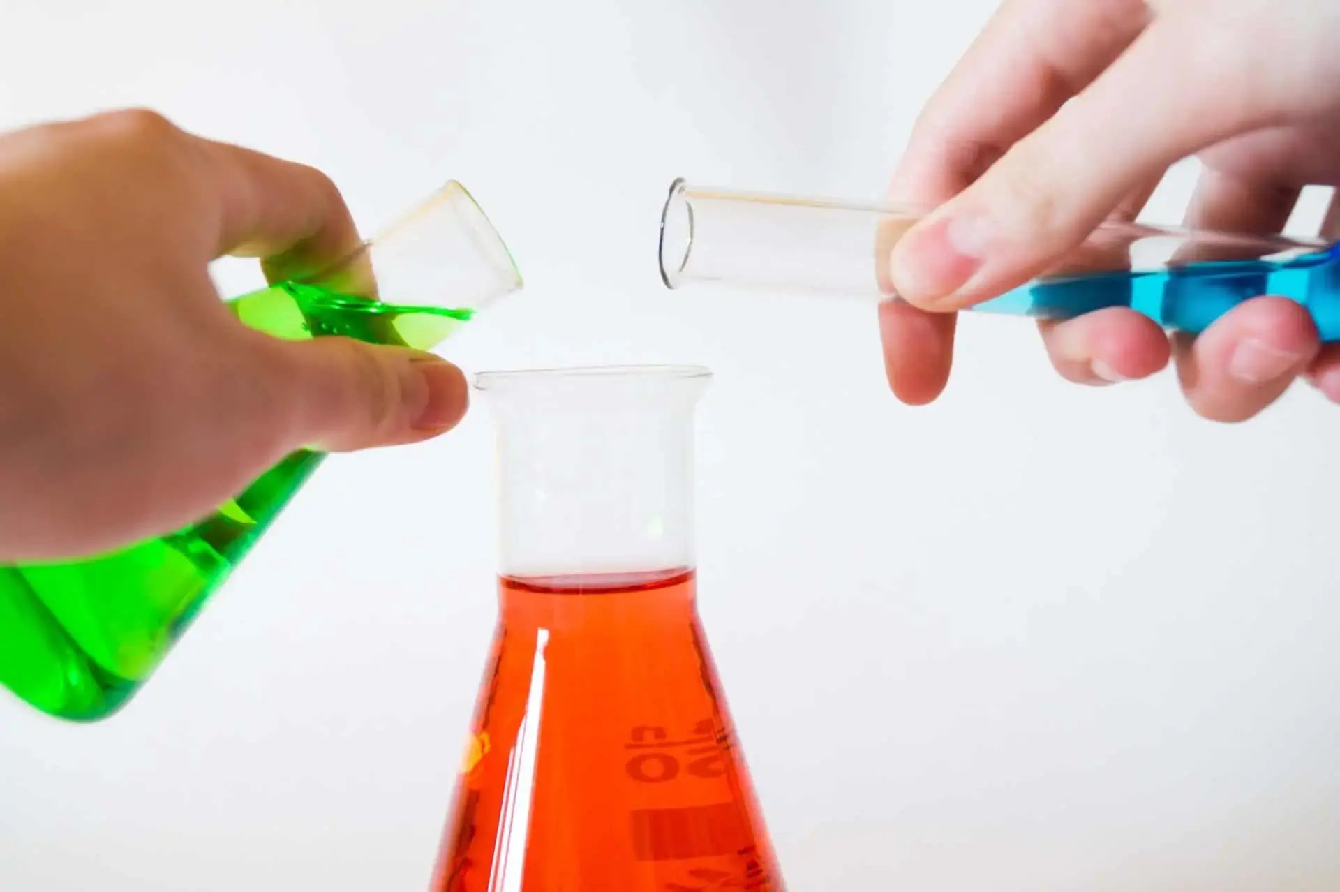 Two persons mixing liquids with lab equipment