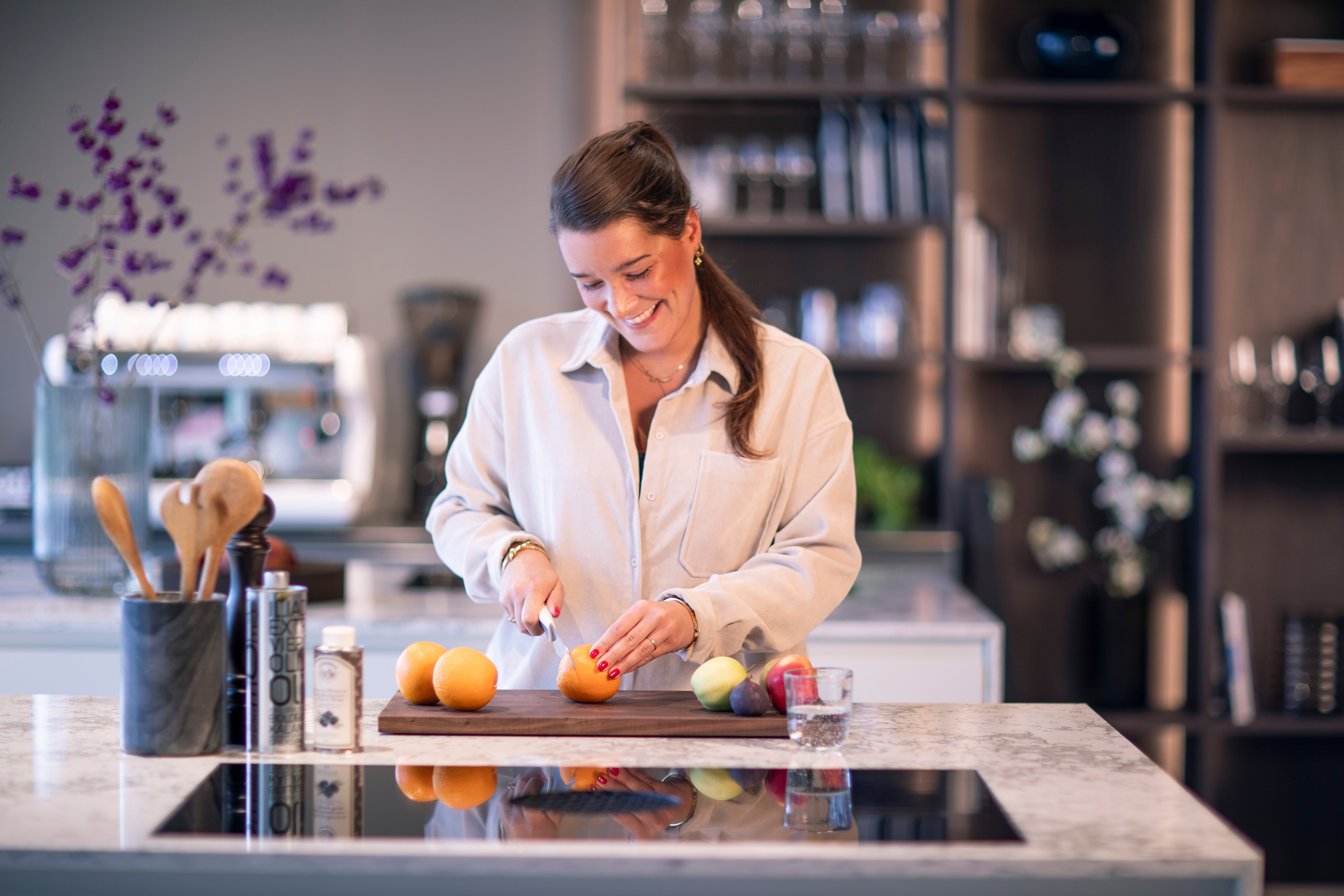 A woman standing in the LEICHT Amsterdam kitchen showroom